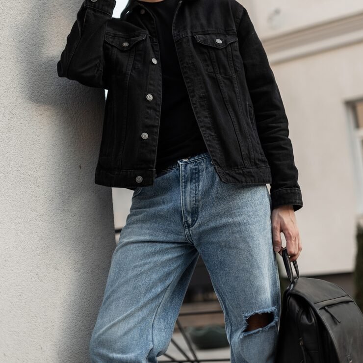 fashionable-handsome-man-black-denim-shirt-with-black-t-shirt-blue-classic-jeans-holds-black-leather-backpack-street_338491-8223